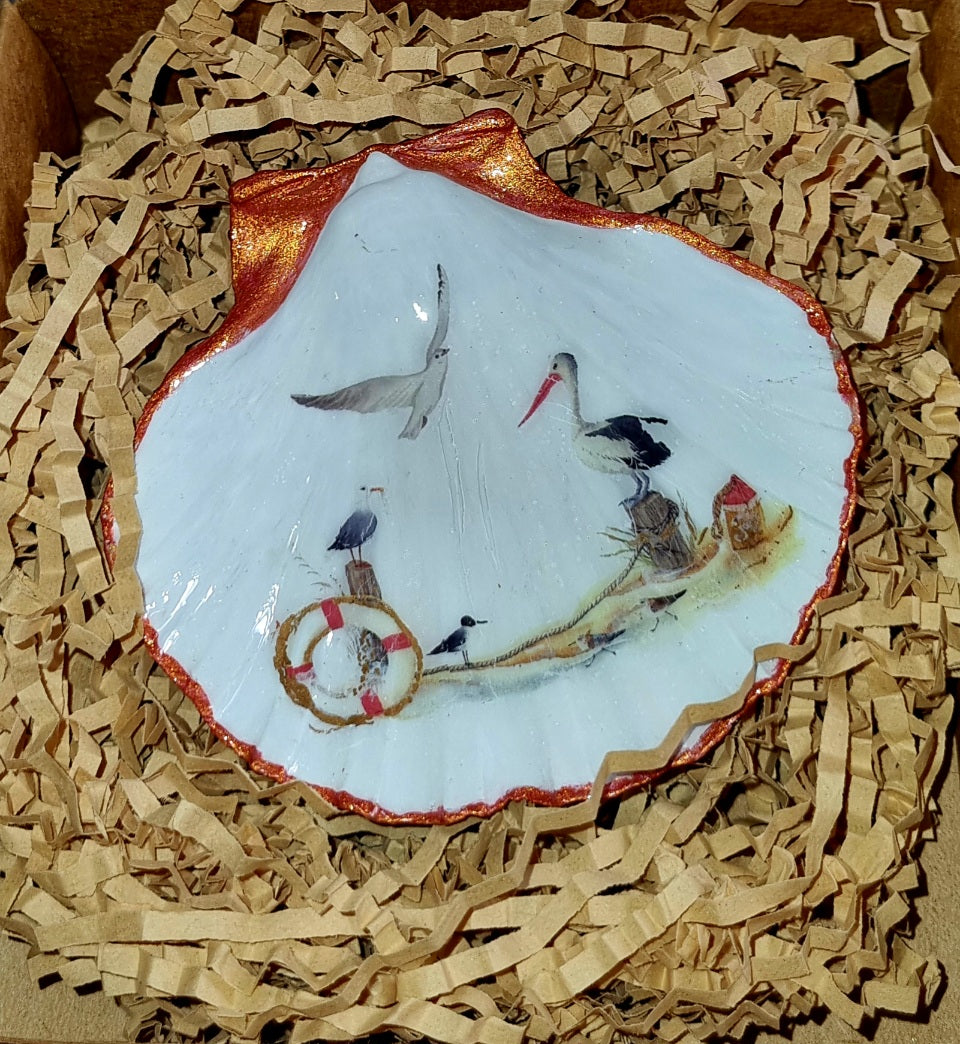 Decorative shell with painted scene of birds and a life buoy on crinkled brown paper